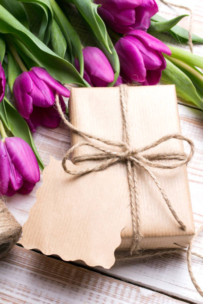 istock Gift box and tulips bouquet on white wooden background - retro style 658201788