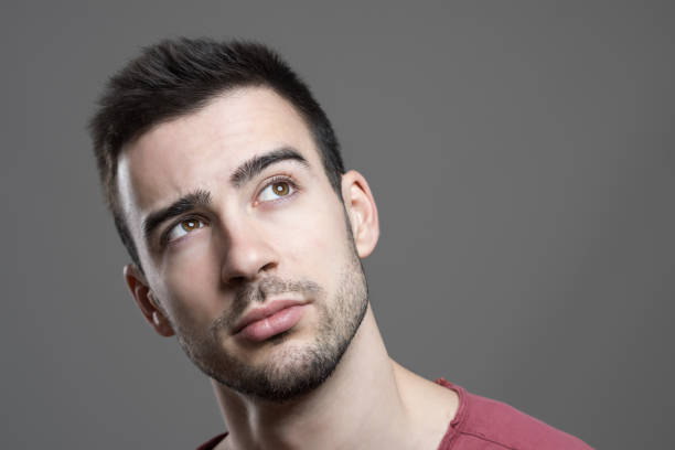 istock Thoughtful young stubble man looking up with copy space 658213792