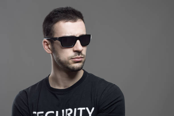 istock Macho tough security agent wearing sunglasses looking away at copyspace. 658213876