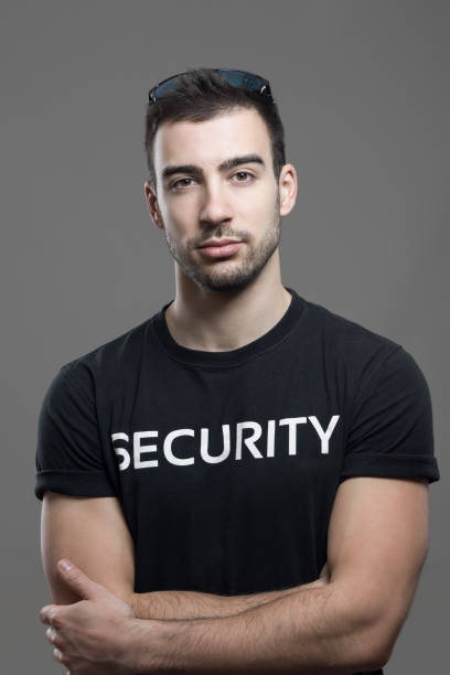 istock Cool fit security guard in black shirt with crossed arms looking at camera. 658214324