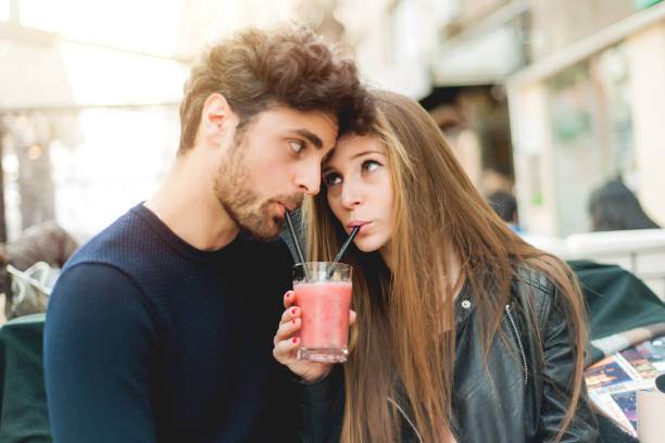 Couple or friends sharing a milkshake stock photo
