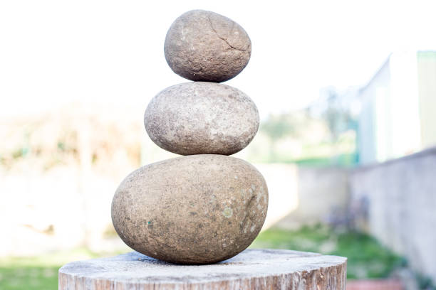 Three smooth stones on sand wooden trunk