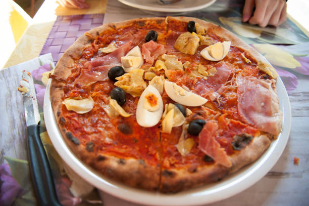 istock Italian pizza with ham and artichokes 658236336