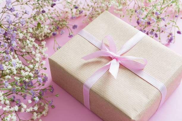 istock Pink background with lilac and white flowers and a present 658237052