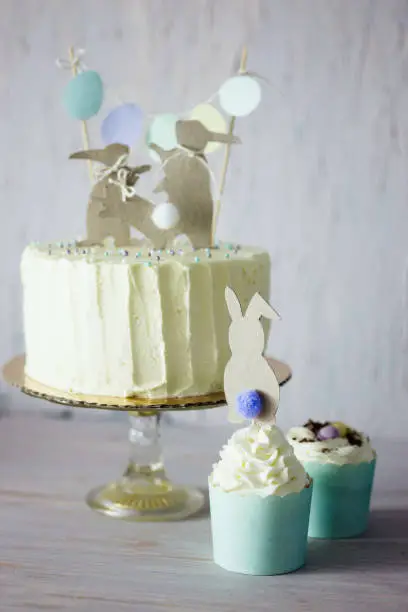 Photo of Easter themed wedding or birthday cake, with paper rabbit silhouettes as cake topper.