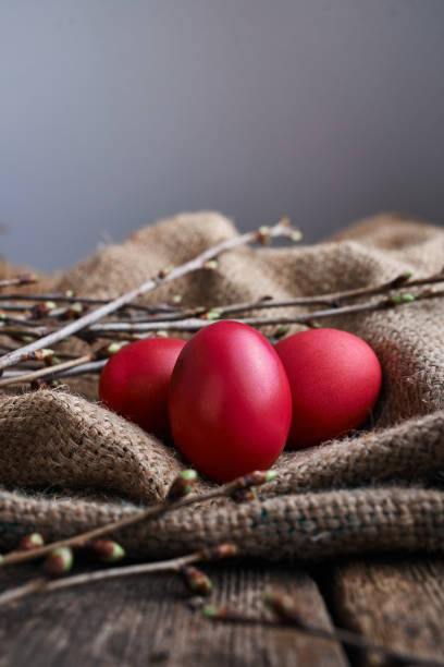 three easter eggs, spring branches on the material from the bag - easter eggs red imagens e fotografias de stock