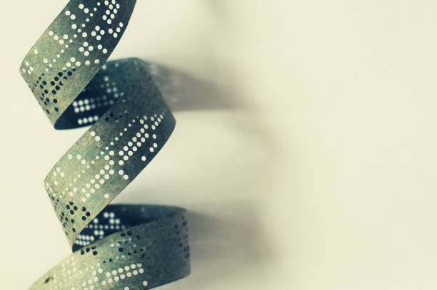 istock Strips of old punched tape on a white surface 658266626
