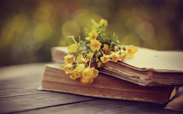 istock Bouquet of buttercups on old books on a table. 658322314