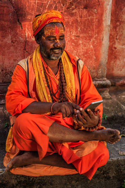 istock Sadhu - indian holyman using mobile phone 658325898