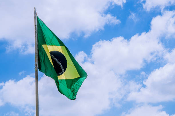 istock Brazil flag on top with blue sky in the background 658328694