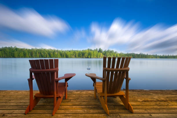 istock Wood Muskoka chairs on a lake deck 658336722