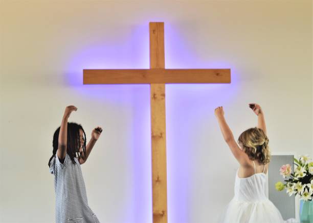 istock Two girls dance before a cross 658336890