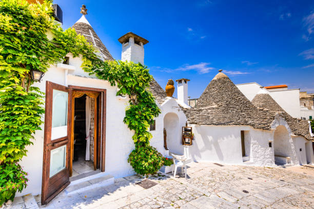 Alberobello, Puglia, Italy ALBEROBELLO, ITALY - 10 JULY 2015: Alberobello, UNESCO heritage city in Italy, Puglia. Trulli or Trullo houses with conical roofs,  traditional Apulian dry stone hut. trulli house stock pictures, royalty-free photos & images