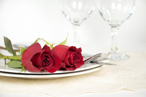 istock red roses on dinner plate with wine glasses 658343550