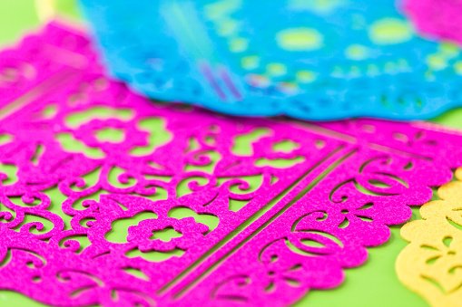 Traditional Mexican papel picado paper banner on a wood background.