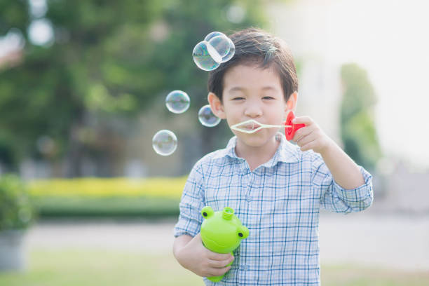 istock Cute asian child is blowing a soap bubbles 658352350