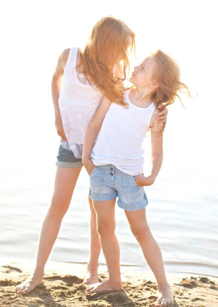 istock portrait of two sisters walking on the beach 658374542