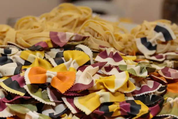 Colorful Butterfly Uncooked Italian Pasta and Tagliatelle Pasta in Background