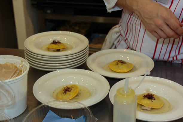 istock Chef Preparing Ravioli Italian Pasta with Red Vegetable with Sauce inside white Dishes 658390516