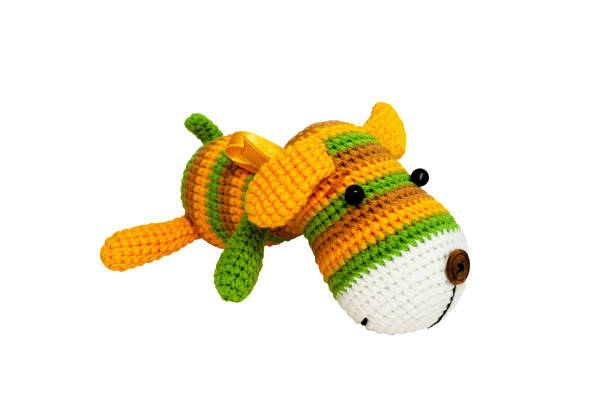 istock Knitted toy - striped lying dog. 658396660