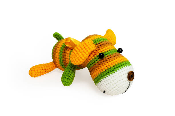 istock Knitted toy - striped lying dog. 658396696