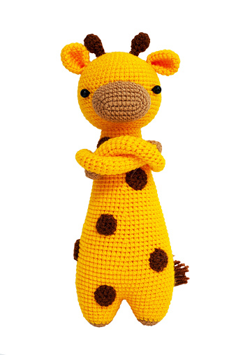 Knitted toy - yellow giraffe on white background, isolated.