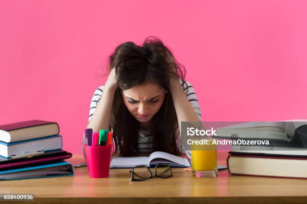 Young Student With Desperate Expression Sitting At Her Desk Stock Photo - Download Image Now