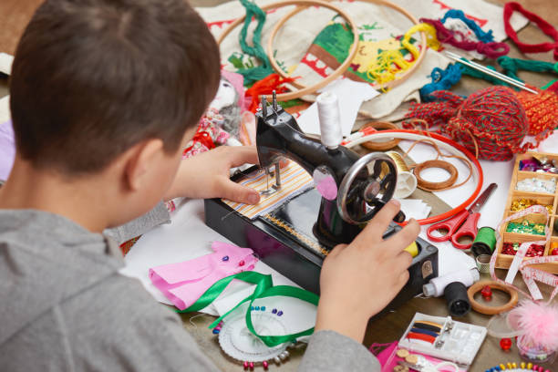 istock boy tailor learns to sew, job training, handmade and handicraft concept 658404290