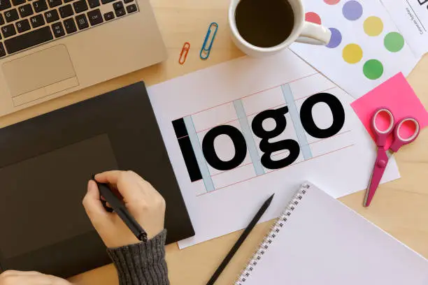 Creative graphic designer using a graphics tablet at work. Logo design concept. Flat lay