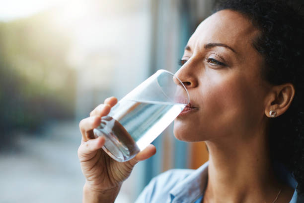 keep calm and hydrate on - transparent holding glass focus on foreground imagens e fotografias de stock