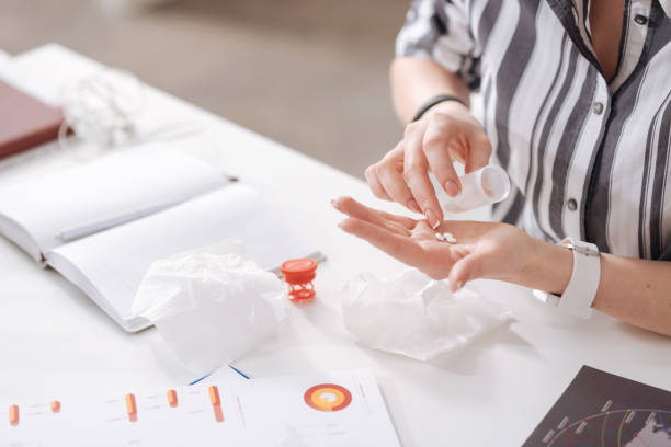 istock Female fingers counting medicine on the palm 658416084