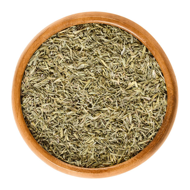 istock Dried minced thyme in wooden bowl over white 658418516