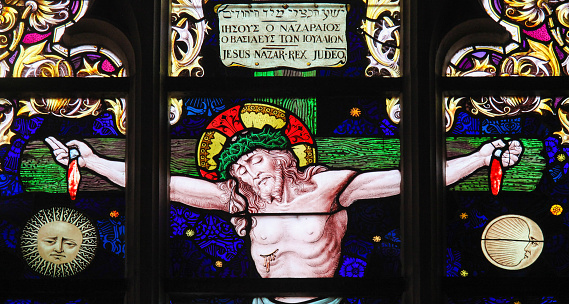 Stained Glass in the Church of Our Blessed Lady of the Sablon in Brussels, Belgium, depicting Jesus on the Cross with a sign 