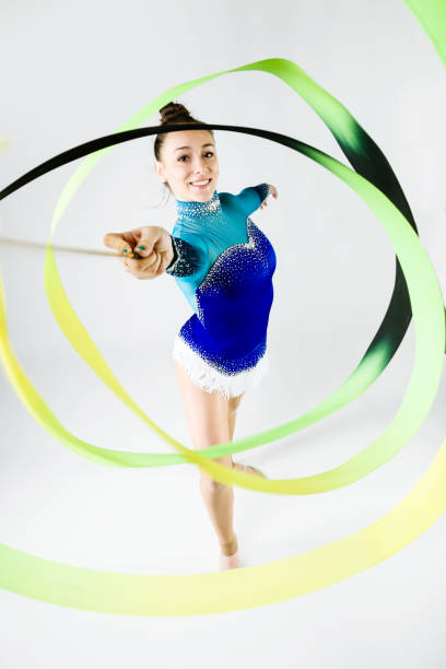 istock Beautiful gymnast athlete doing exercise with ribbon. Isolated on white. 658419442