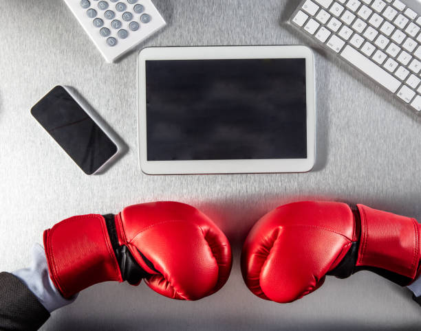 istock businessman hands with conflicted boxing gloves facing technology, flat lay 658425992