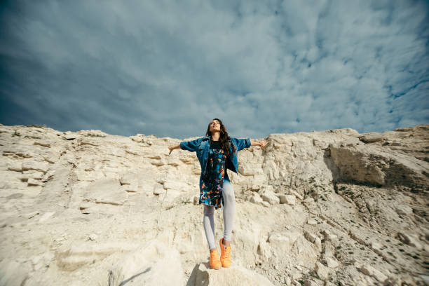 istock Young woman dressed colorful clothes posing and dancing 658427356