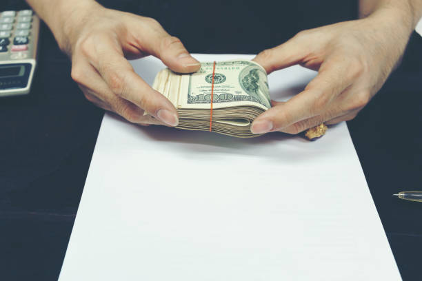 istock Male 's hands holding folded U.S dollar bills 658430424