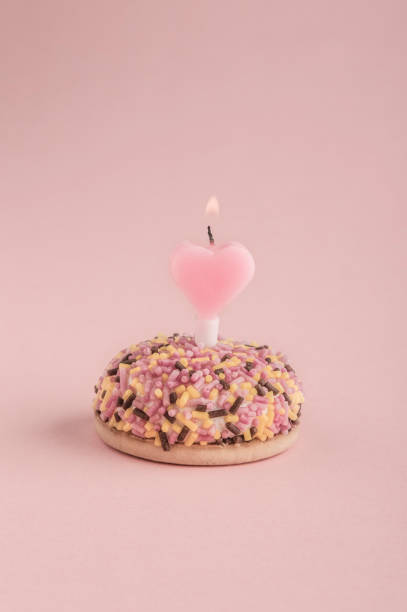 istock birthday cake with heart shaped candle on pink 658443580