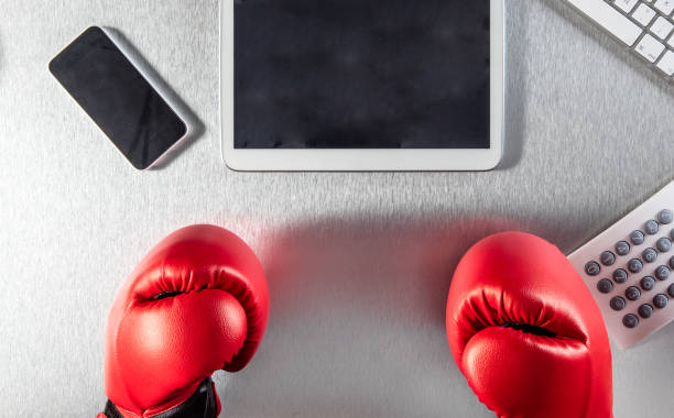 istock embarrassed business hands with boxing gloves facing digital media screens 658444238