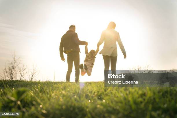 Happy Family Heaving Fun In The Park Stock Photo - Download Image Now - Family, Rear View, Walking