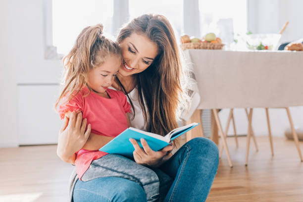 istock Mother and daughter reading a book together 658448762