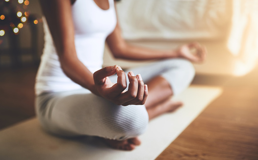 Cropped shot of an unrecognizable young woman practicing yoga indoors