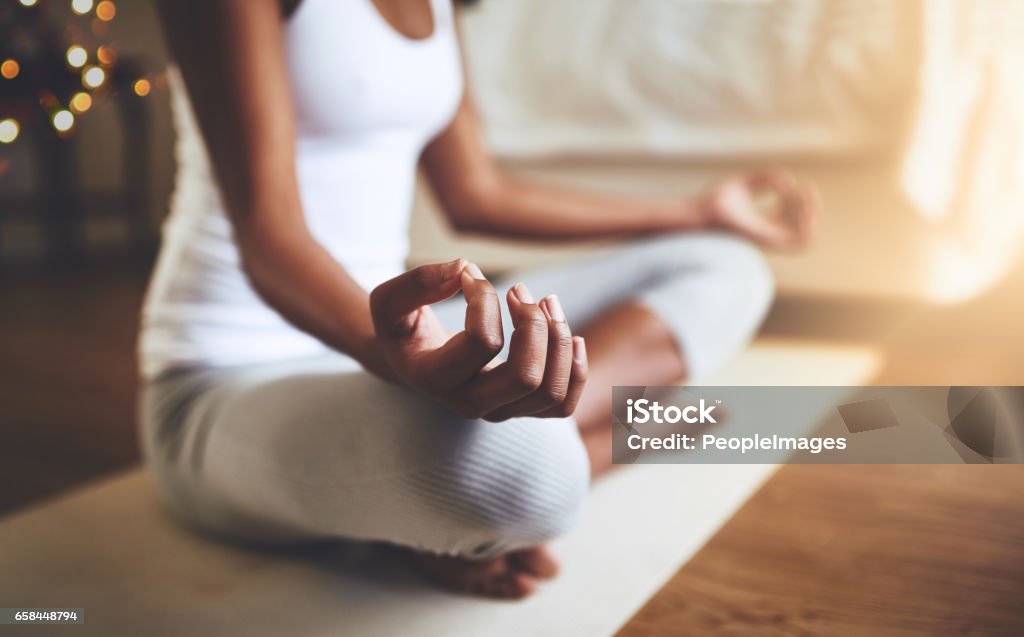It's about a balance Cropped shot of an unrecognizable young woman practicing yoga indoors Meditating Stock Photo