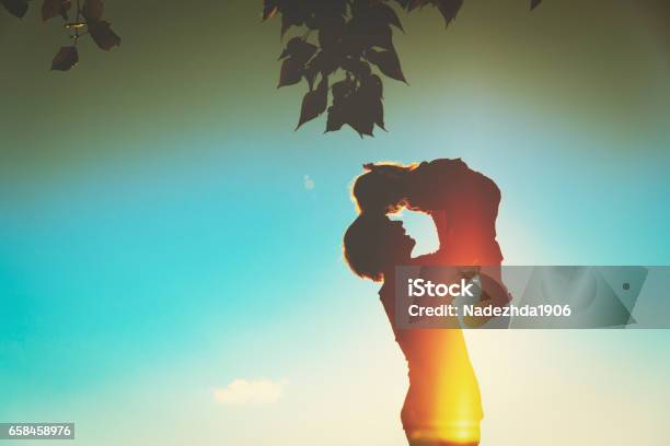 Father And Little Daughter Silhouettes Play At Sunset Stock Photo - Download Image Now