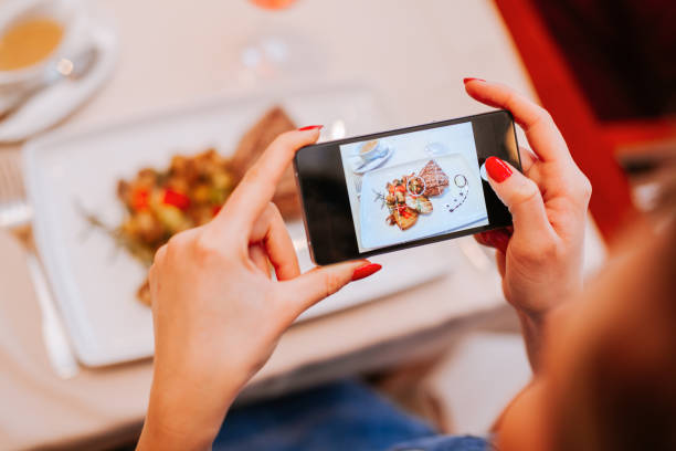 A Young Woman Taking A Photo A Young Woman Taking A Photo Of Food On A Plate photo messaging stock pictures, royalty-free photos & images