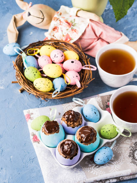istock Easter sweet cup cakes treets in colorful egg shells on blue 658468746