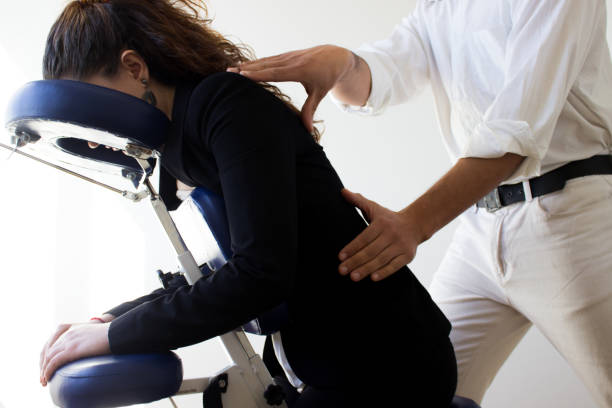 бизнес-женщина получать шиацу на быстром массажном кресле - massaging alternative medicine headache women стоковые фото и изображения
