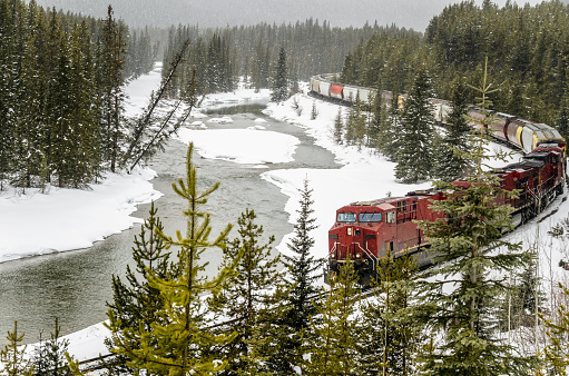 Banff, Canada -November 2019: Canadian Pacific train (CP Rail) passing through the famous Morant's Curve, located in Banff National Park, Alberta. The scene in featured on the $10 bill.