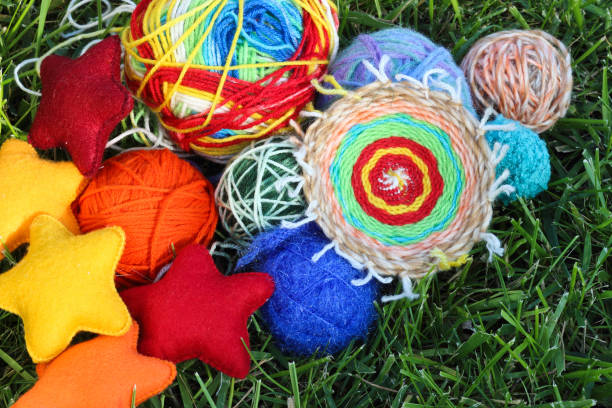 Colorful knitting balls from wool and fabric textile stars on green grass