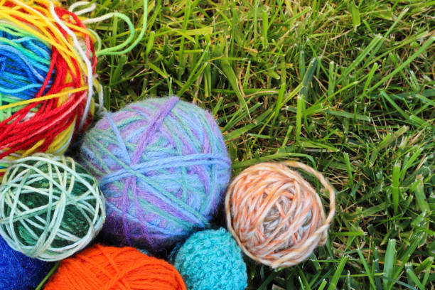 istock Colorful knitting balls from wool and fabric textile stars on green grass 658480686